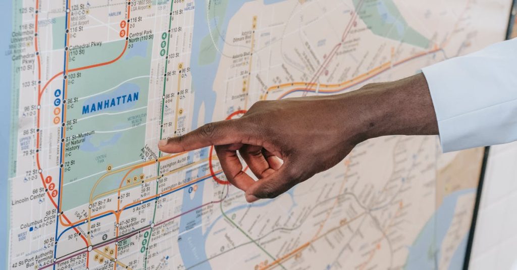 Close-up of a hand pointing at a Manhattan subway map, emphasizing transportation guidance.